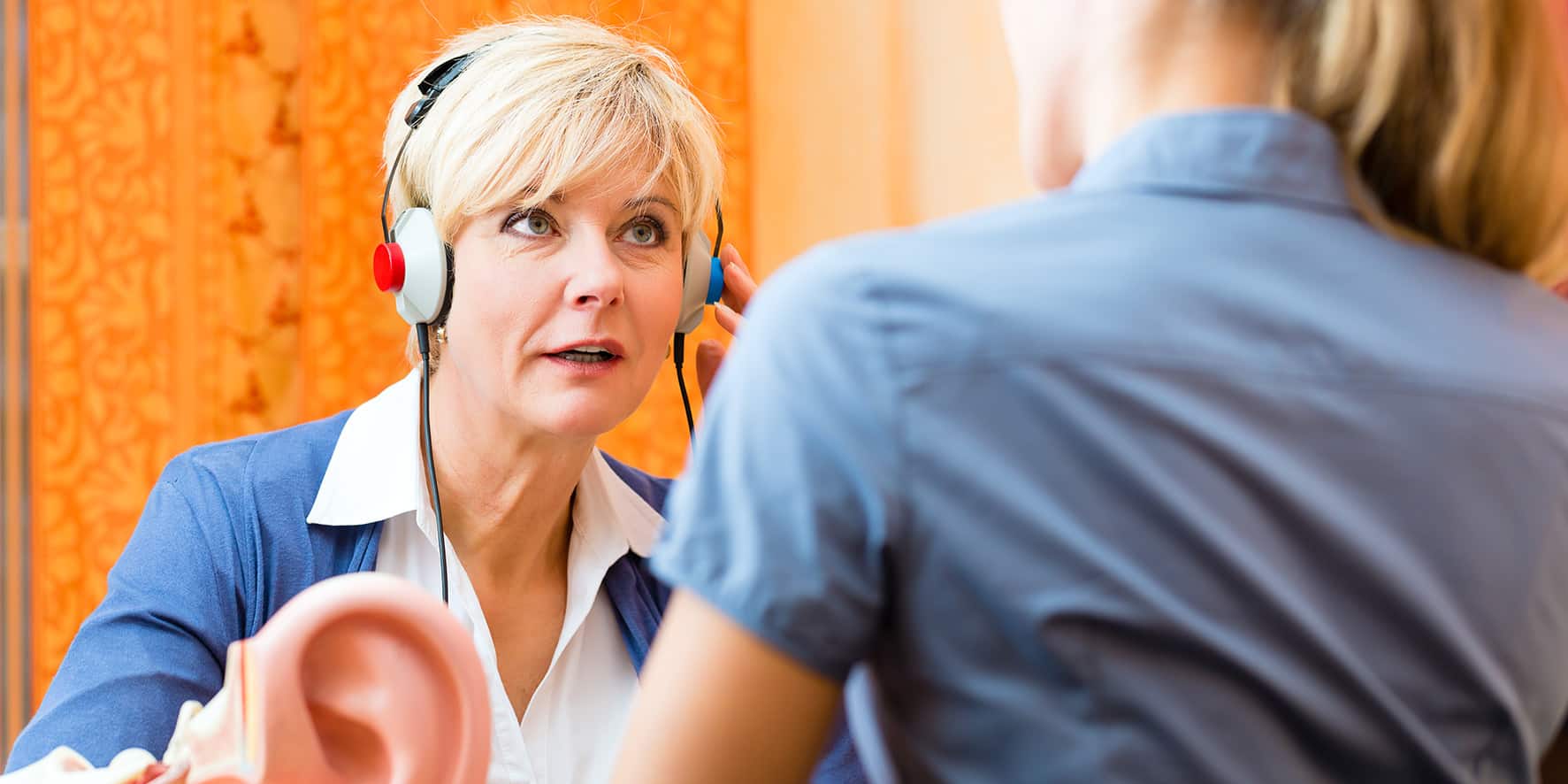 A woman listens through headphones as part of a hearing test